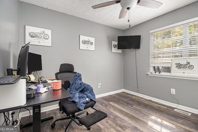 office featuring visible vents, a ceiling fan, a textured ceiling, wood finished floors, and baseboards