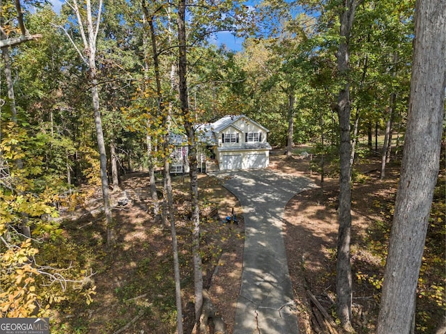 view of front of home with a wooded view and driveway