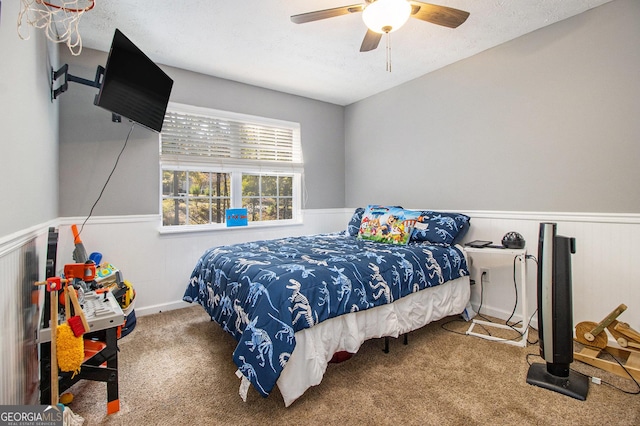 bedroom featuring carpet, ceiling fan, and a textured ceiling