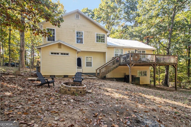 rear view of house with stairway, a fire pit, and a deck