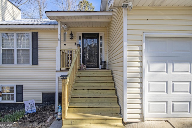 doorway to property featuring metal roof and a garage