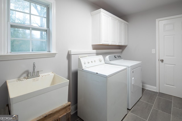 clothes washing area featuring cabinets, sink, washer and dryer, and dark tile patterned flooring