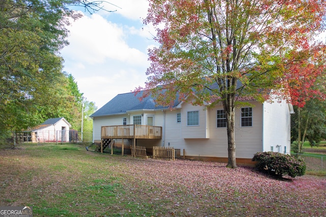 rear view of house with a deck and a yard