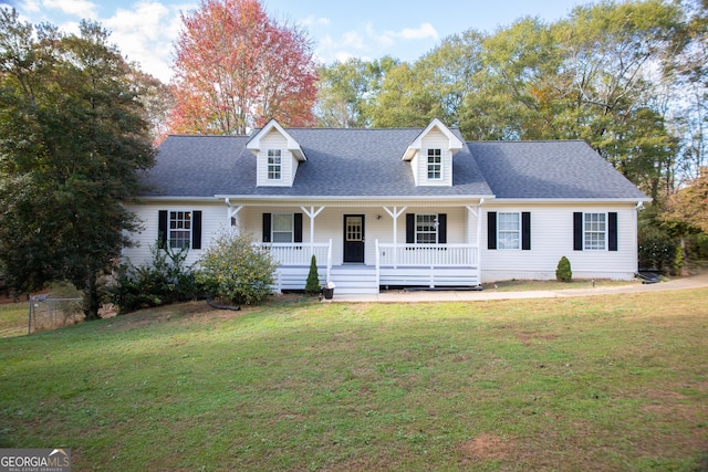 new england style home with covered porch and a front lawn