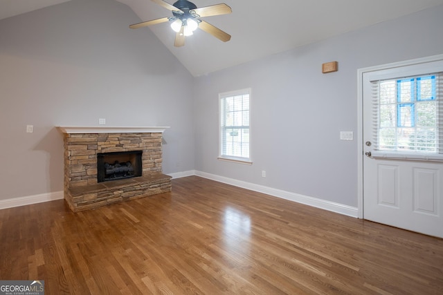 unfurnished living room featuring ceiling fan, wood-type flooring, a fireplace, and high vaulted ceiling