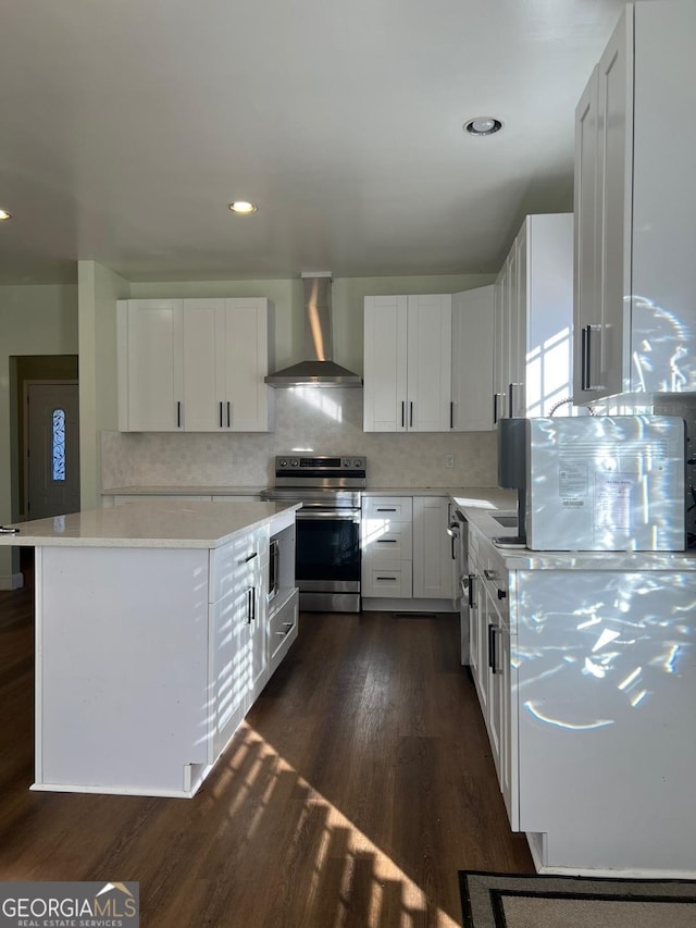 kitchen with decorative backsplash, wall chimney exhaust hood, white cabinets, dark hardwood / wood-style floors, and stainless steel range with electric cooktop