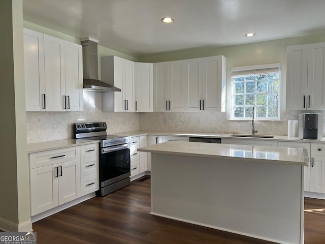 kitchen with dark wood-type flooring, electric stove, sink, a kitchen island, and white cabinetry