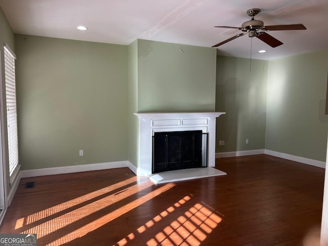 unfurnished living room featuring ceiling fan and dark wood-type flooring