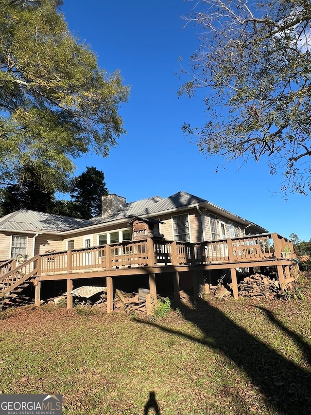 back of house with a wooden deck and a yard