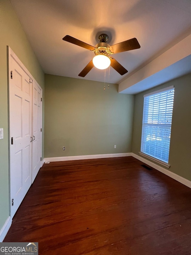 unfurnished bedroom featuring ceiling fan, a closet, and dark hardwood / wood-style floors