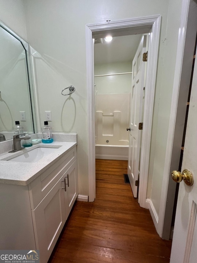 bathroom featuring hardwood / wood-style floors, vanity, and bathtub / shower combination