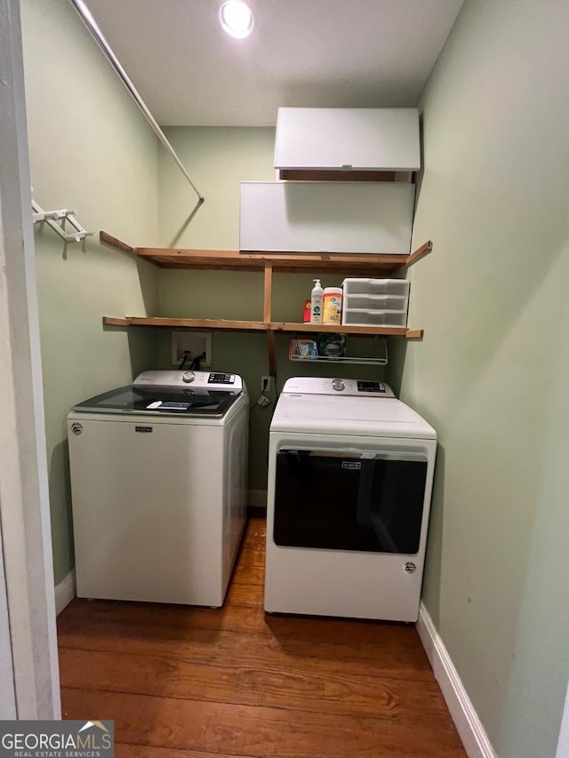 laundry room with wood-type flooring and washing machine and dryer