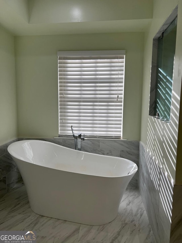 bathroom featuring a bathing tub and tile walls