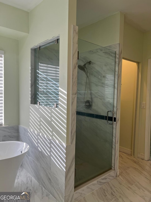 bathroom featuring shower with separate bathtub