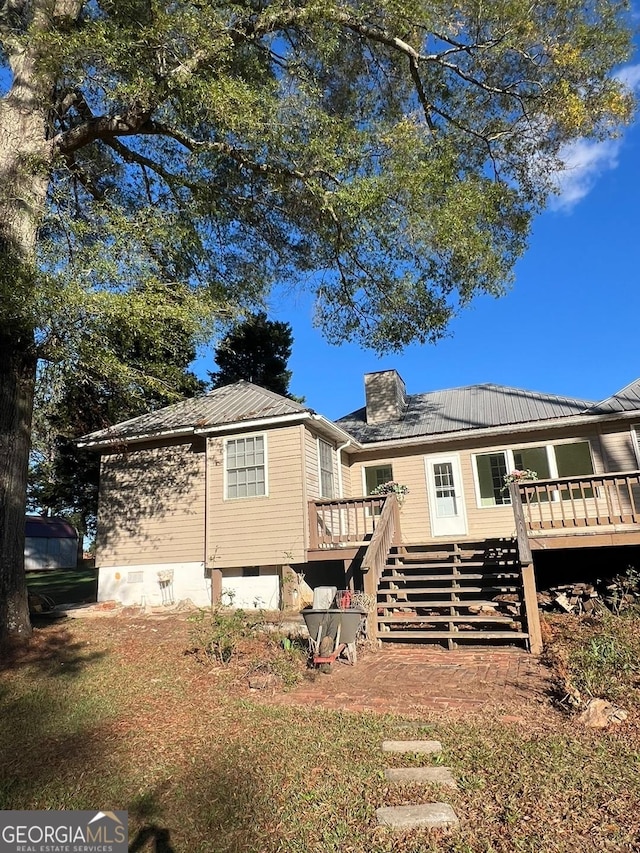 rear view of house featuring a wooden deck