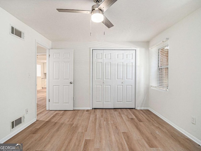 unfurnished bedroom with a closet, light hardwood / wood-style flooring, and ceiling fan