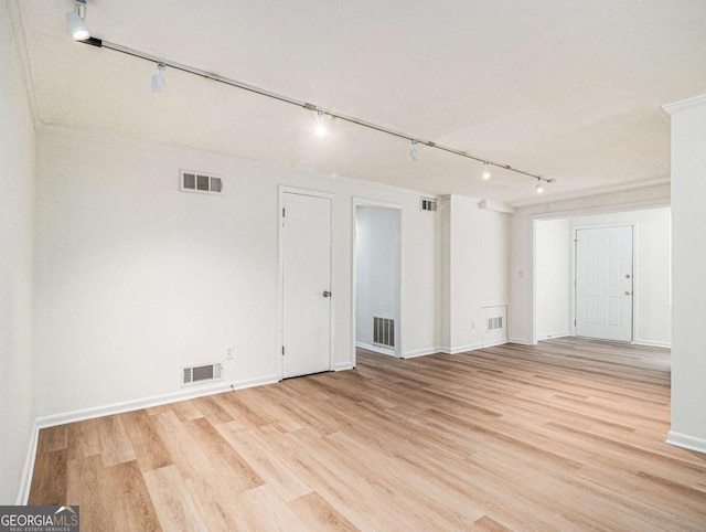 spare room with light hardwood / wood-style flooring, rail lighting, and ornamental molding