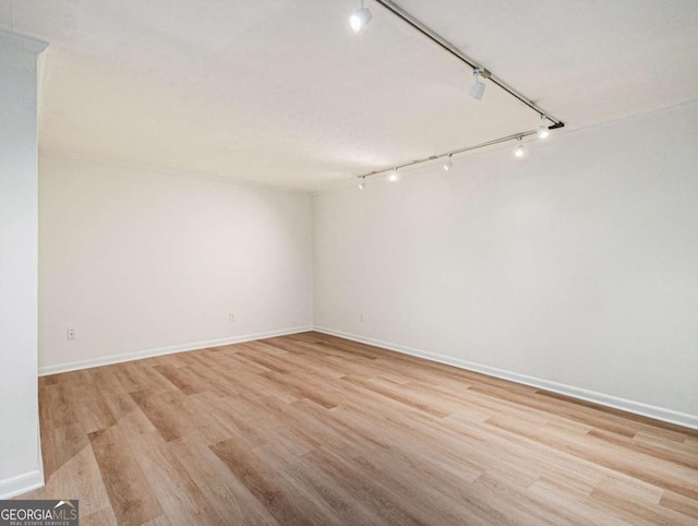 unfurnished room with rail lighting and light hardwood / wood-style floors