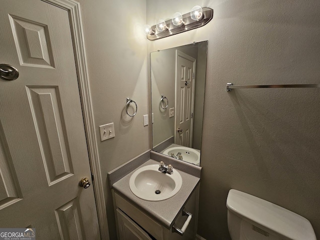 bathroom featuring toilet and vanity