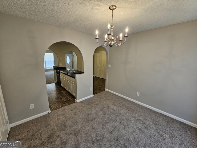 unfurnished dining area with arched walkways, dark colored carpet, a chandelier, and a sink