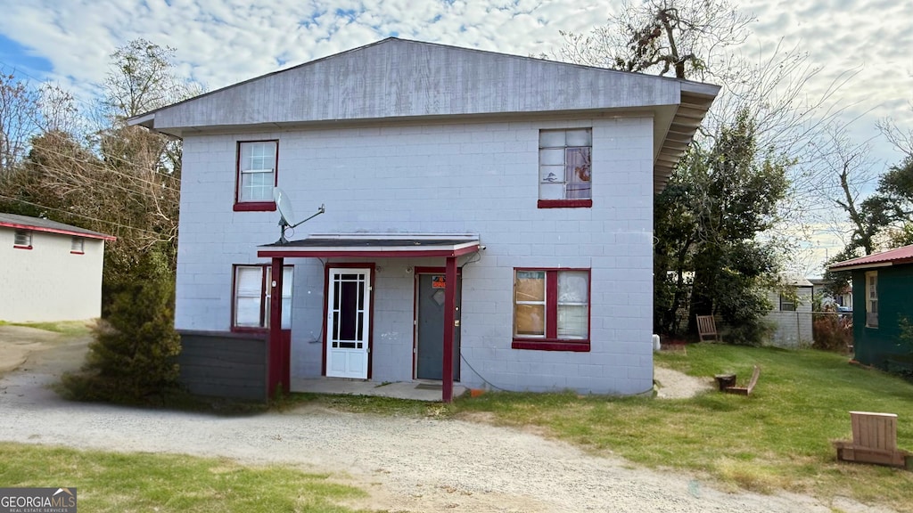 back of house featuring a lawn