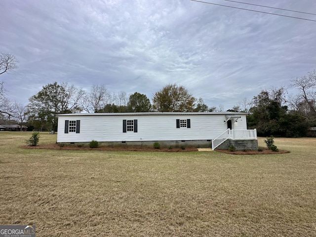 rear view of property featuring a lawn