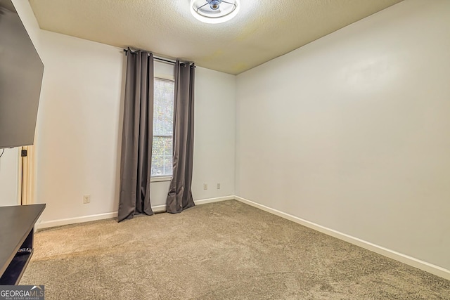 unfurnished room featuring light carpet and a textured ceiling