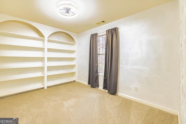 carpeted spare room featuring a textured ceiling