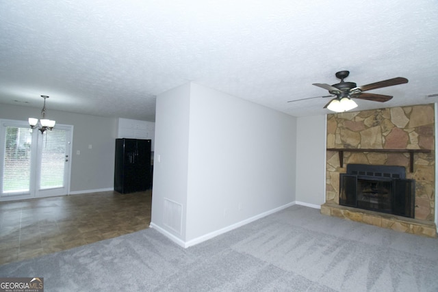 unfurnished living room with a textured ceiling, ceiling fan with notable chandelier, carpet flooring, and a fireplace