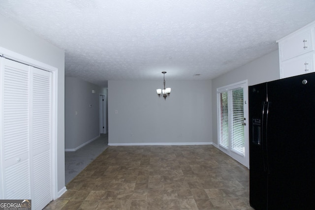 interior space featuring a textured ceiling and a chandelier