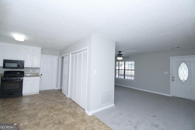 kitchen with black appliances, white cabinets, ceiling fan, a textured ceiling, and light colored carpet