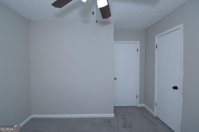 carpeted empty room featuring ceiling fan and a textured ceiling