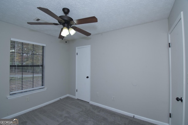 carpeted empty room with a textured ceiling and ceiling fan