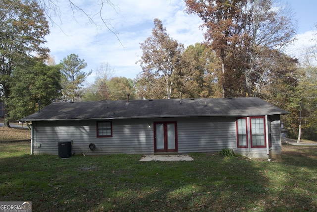 back of property featuring a lawn and central AC