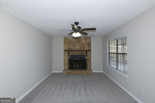 unfurnished living room featuring carpet, a fireplace, ceiling fan, and a textured ceiling