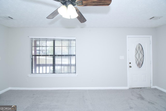 spare room with ceiling fan, carpet, and a textured ceiling