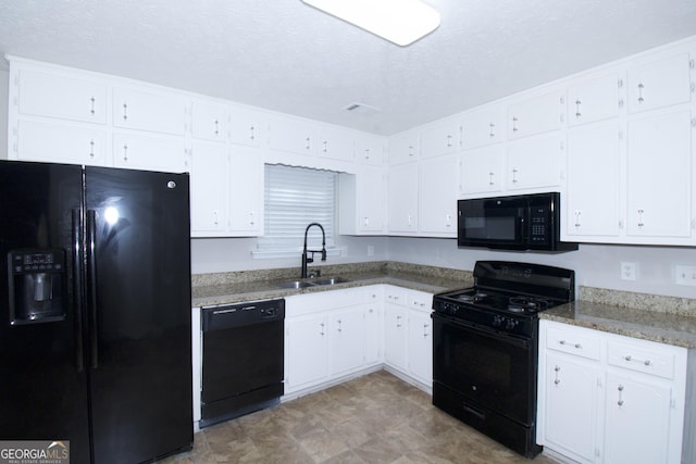 kitchen with light stone counters, a textured ceiling, sink, black appliances, and white cabinets