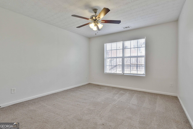 carpeted empty room with ceiling fan and a textured ceiling