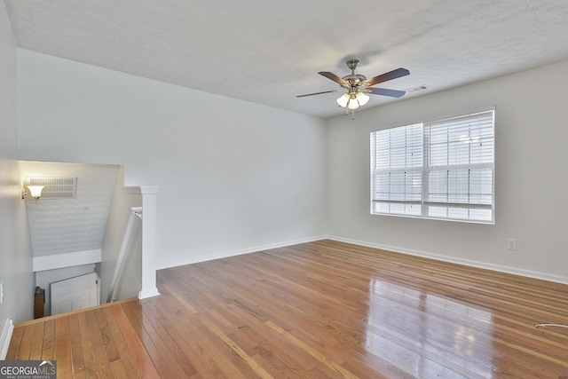 unfurnished living room with wood-type flooring, a textured ceiling, and ceiling fan