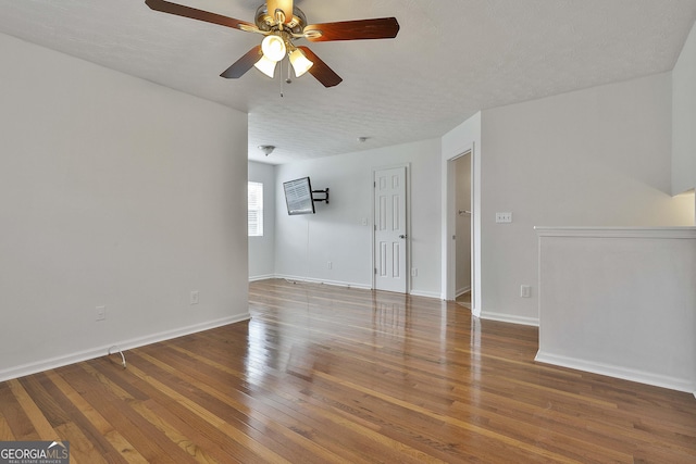 empty room featuring ceiling fan, wood-type flooring, and a textured ceiling