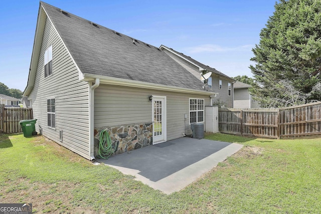 back of house with a yard and a patio