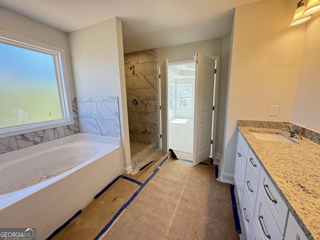 bathroom featuring a stall shower, plenty of natural light, vanity, and a bath