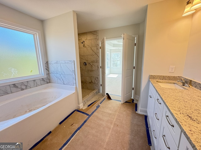 full bathroom featuring a stall shower, a garden tub, plenty of natural light, and vanity