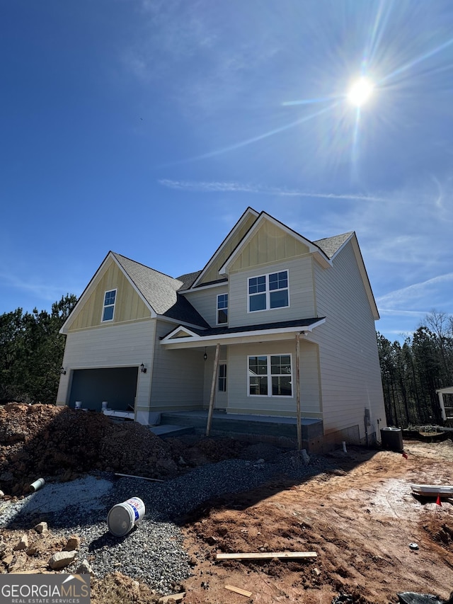 craftsman inspired home featuring a garage, cooling unit, and board and batten siding