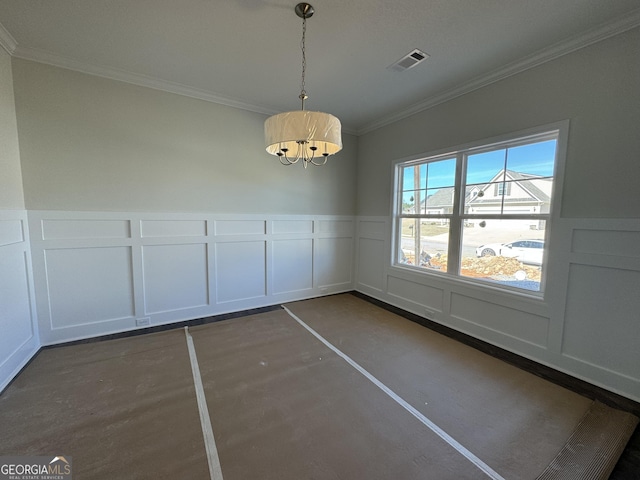 unfurnished dining area featuring crown molding, visible vents, a decorative wall, wainscoting, and concrete floors