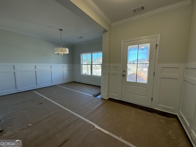 entryway featuring a wainscoted wall, visible vents, a decorative wall, ornamental molding, and a chandelier