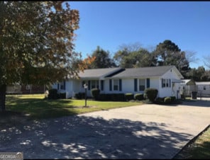 single story home featuring a front lawn