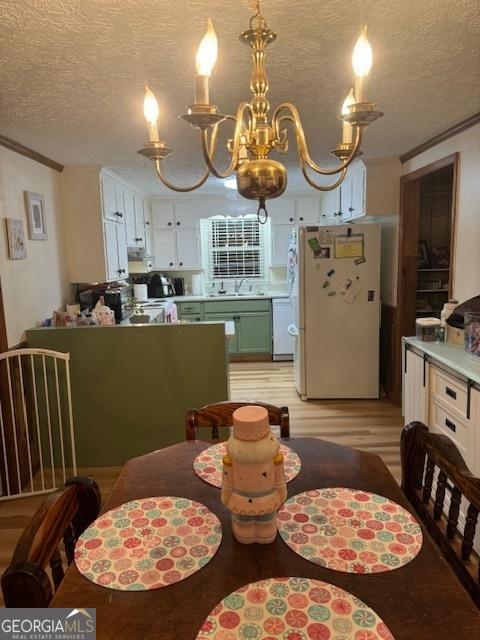 dining space featuring crown molding, a textured ceiling, and a notable chandelier