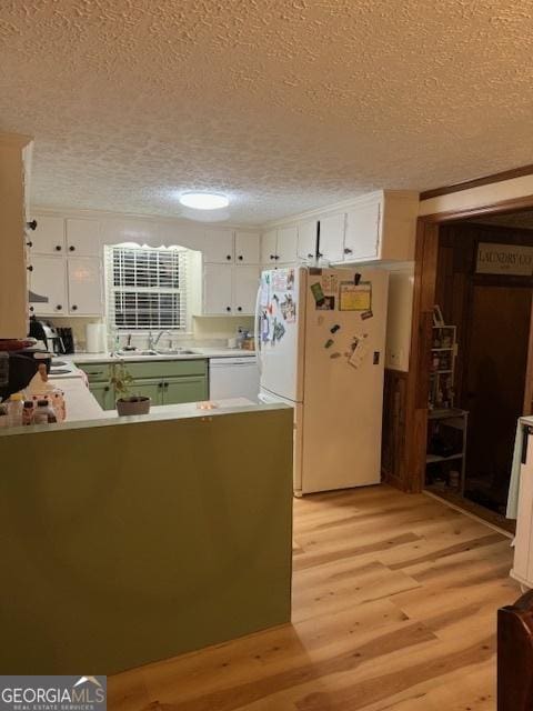 kitchen featuring kitchen peninsula, white appliances, white cabinetry, and a textured ceiling