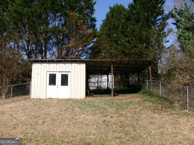 view of outdoor structure featuring a carport and a lawn